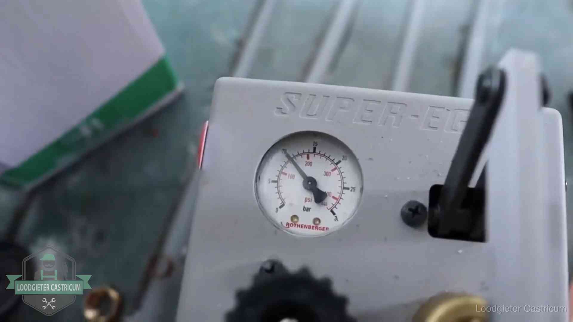 Manometer van een afperspomp bij controle van nieuw leidingwerk in Castricum