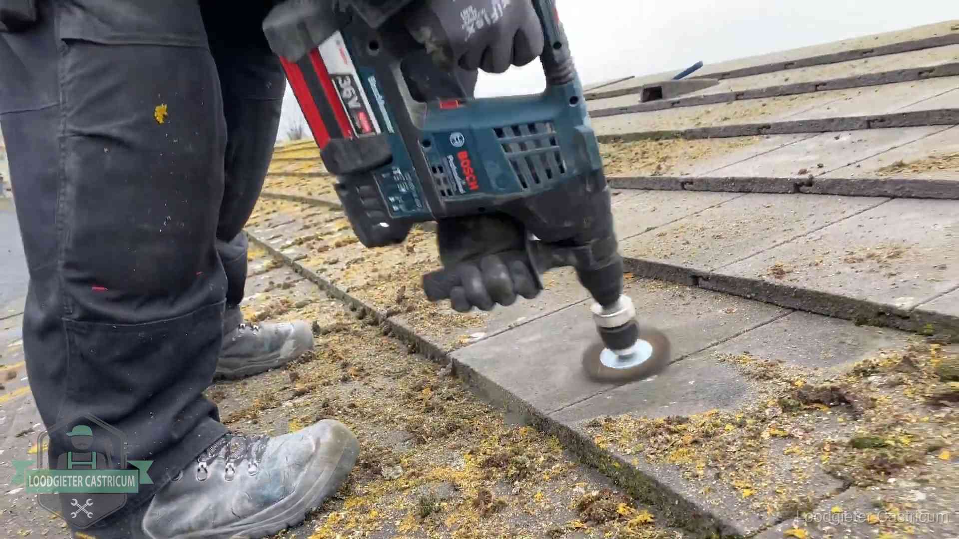 Betonnen dakpannen worden machinaal gereinigd tijdens dakonderhoud in Castricum