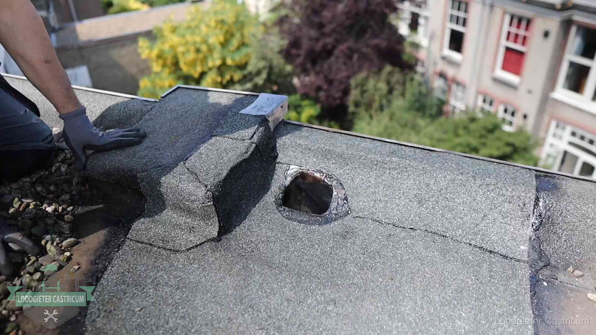Loodgieter inspecteert een beschadigd bitumen plat dak tijdens een daklekkage-inspectie in Castricum