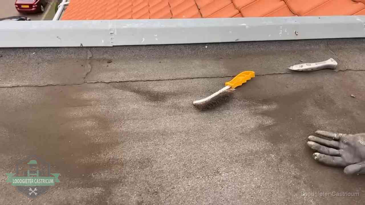 Dakdekker bereidt een bitumen plat dak voor op reparatie bij de daktrim in Castricum