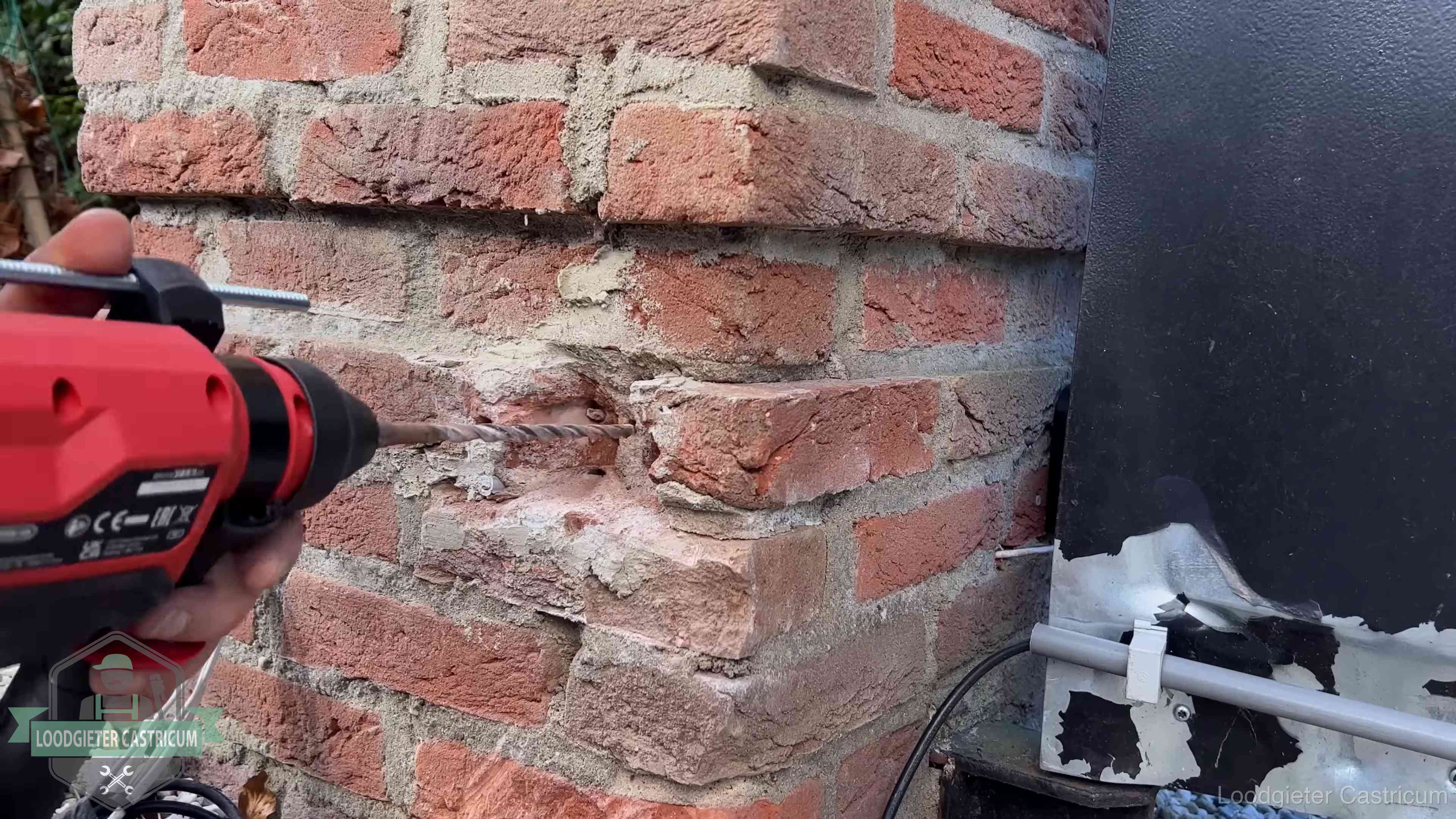 Vakman boort in de buitenmuur van een woning in de regio Castricum
