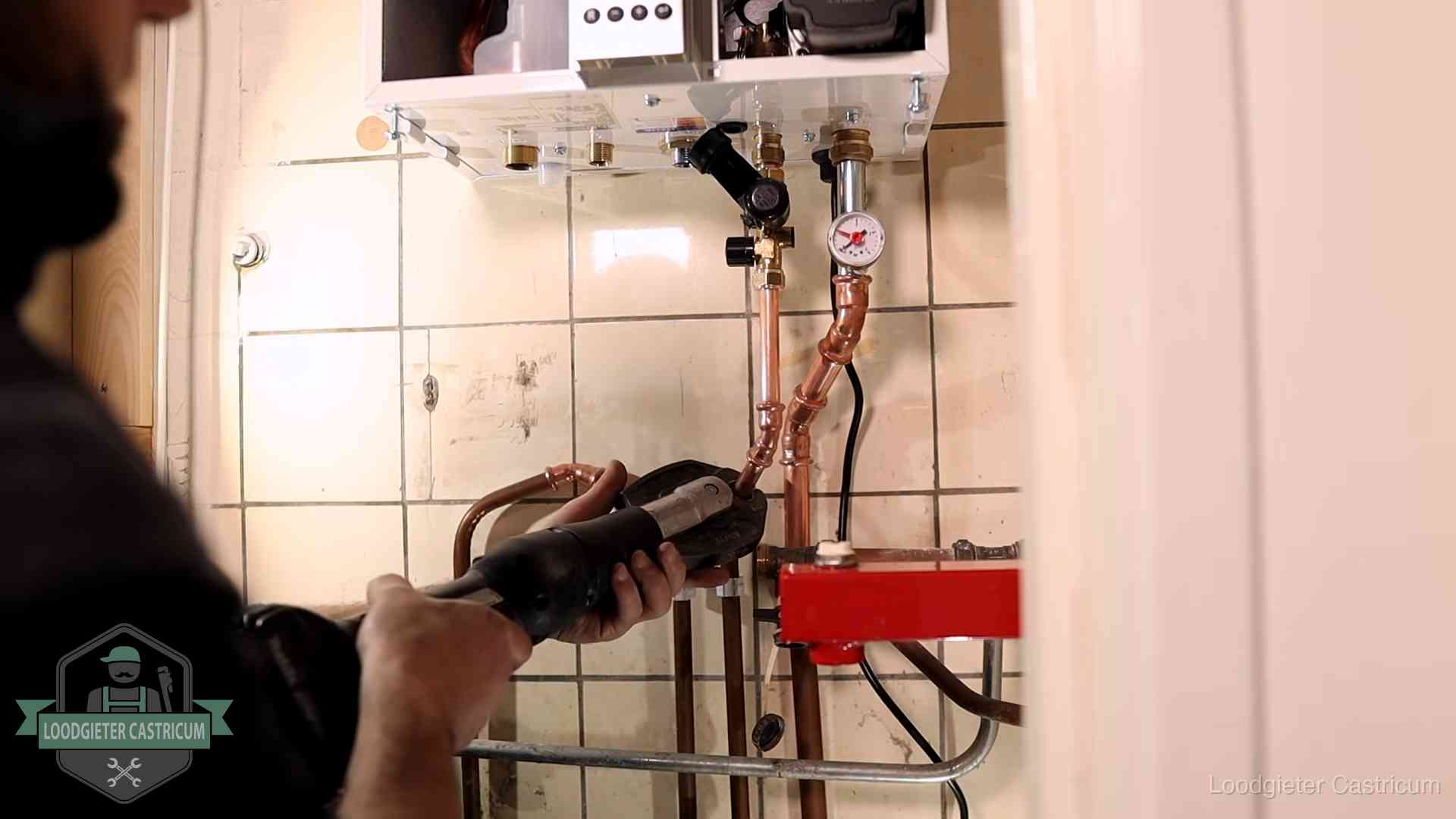 Cv-ketel onderhoud in Castricum Monteur werkt aan de leidingen onder een cv-ketel in Castricum