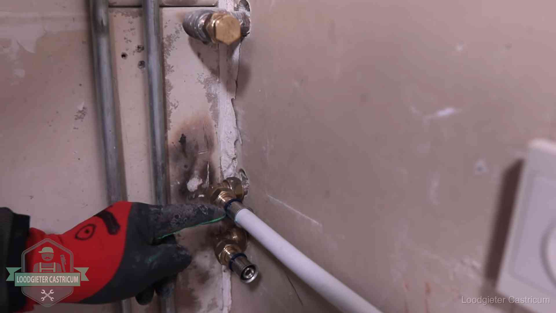 Loodgieter wijst de persfitting op nieuwe muuraansluitingen aan in een woning in Castricum