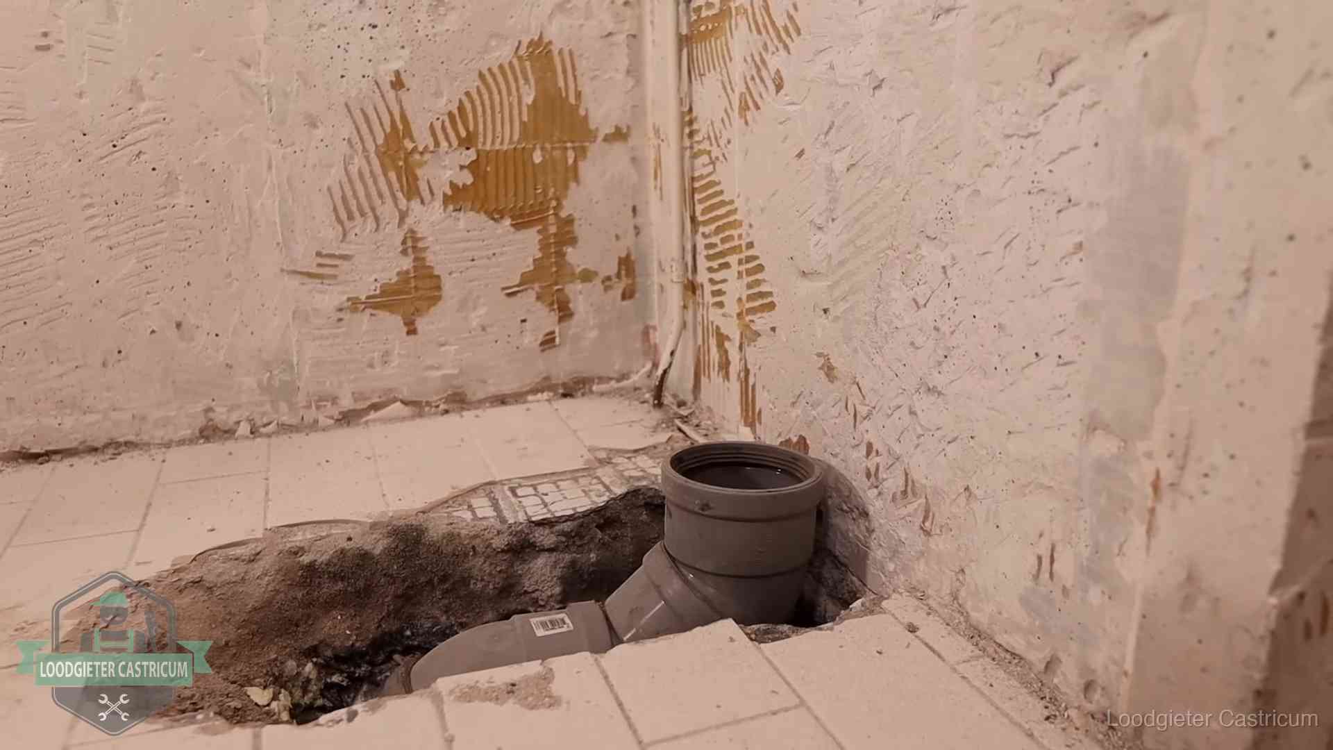 Verzakt riool herstellen in Castricum Opengebroken vloer met een nieuwe pvc-rioolbocht in een gegraven sleuf in Castricum