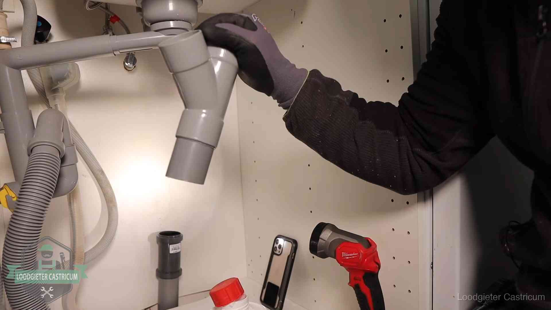Rioollucht in huis verhelpen in Castricum Loodgieter demonteert het sifon- en afvoerwerk onder een gootsteen in Castricum bij stankklachten