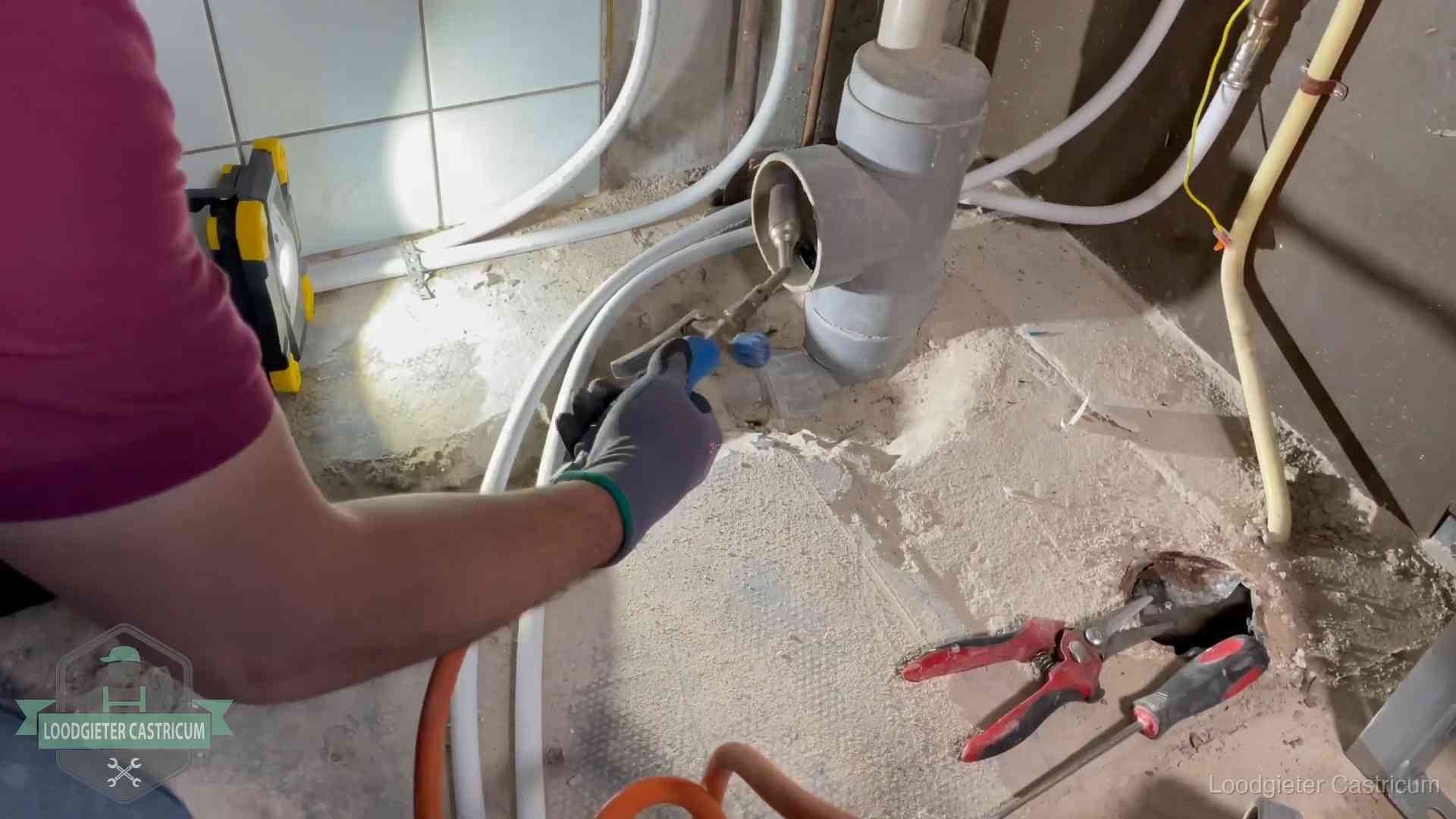 Loodgieter werkt aan leidingen bij een pvc-standleiding in een appartement in Castricum