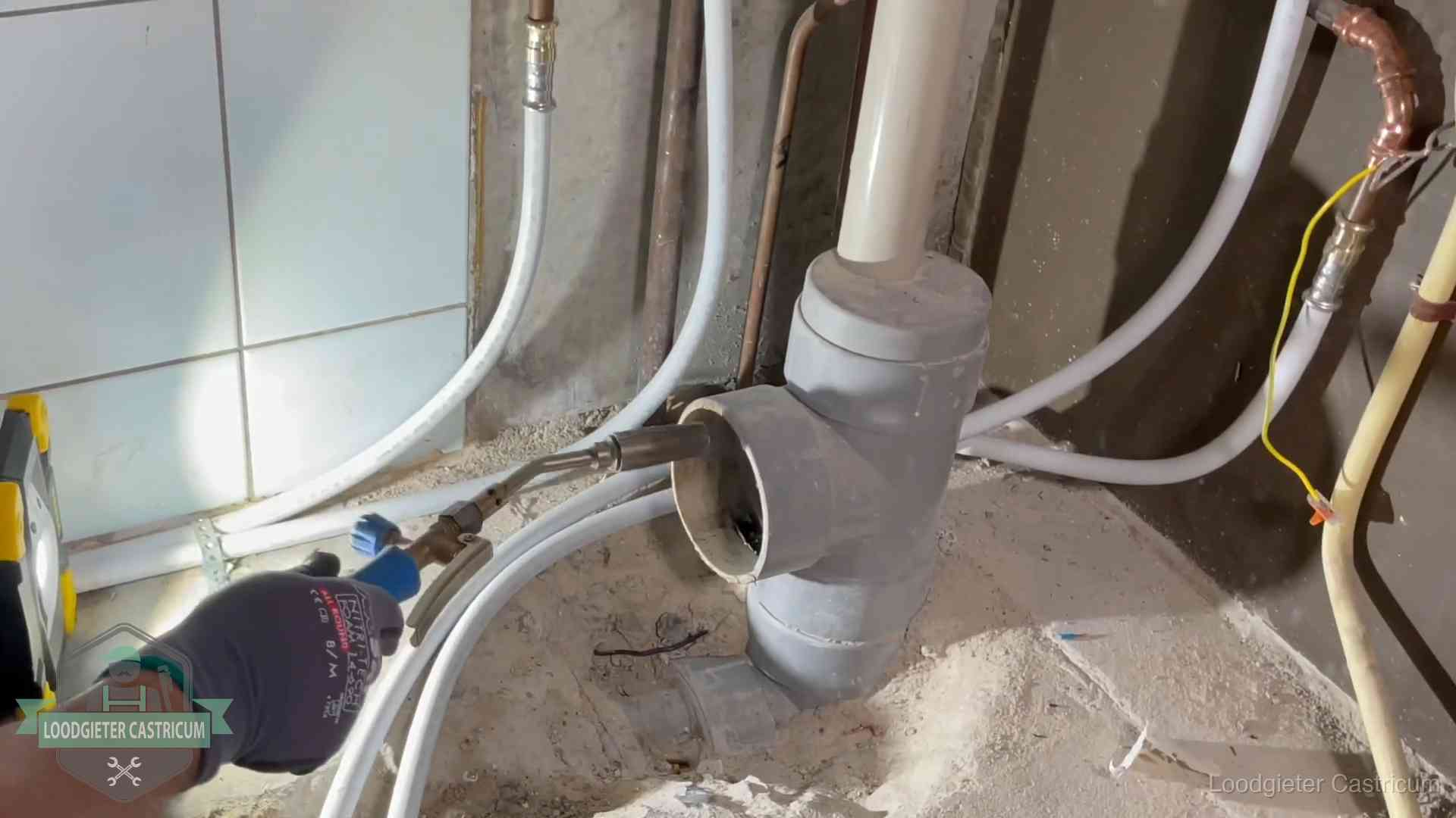 Verstopping in een huurwoning in Castricum Loodgieter werkt aan leidingen bij de pvc-standleiding van een huurwoning in Castricum