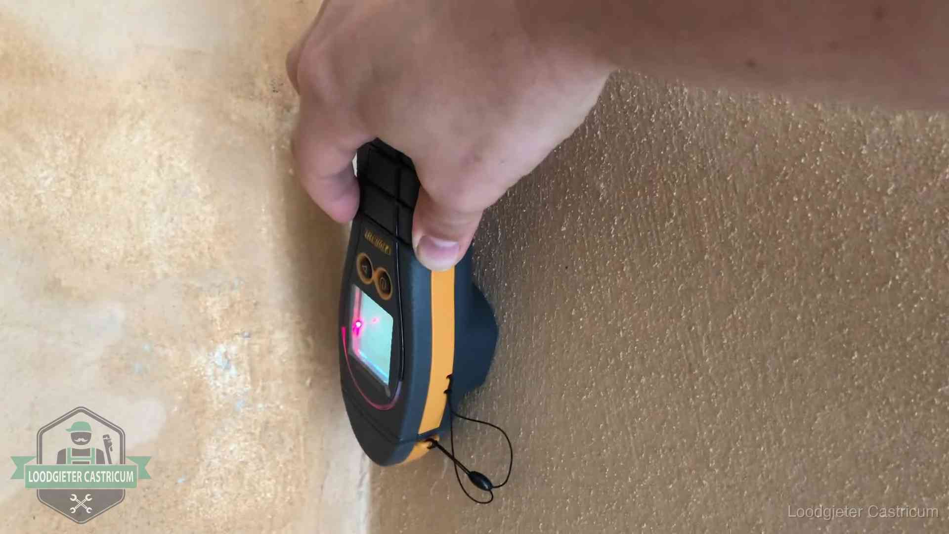 Vochtmeter tegen een muur met vochtplekken tijdens het opsporen van een daklekkage in Castricum