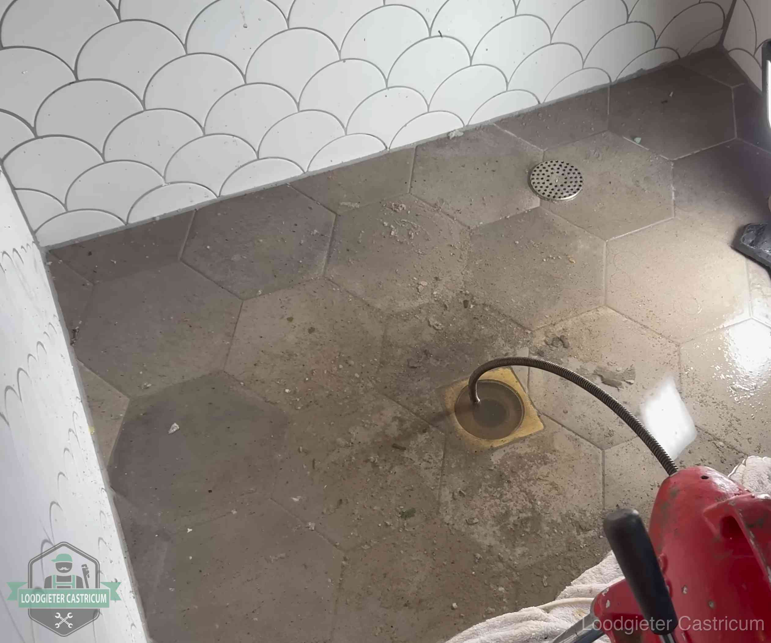 Vloerput met waterslot in een badkamer in Castricum, een bron van stank als het waterslot droogstaat